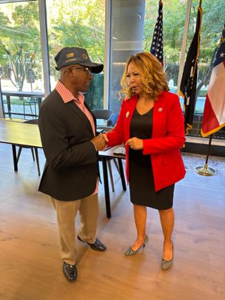 Rep. McBath shakes hands and speaks with a Vietnam veteran.